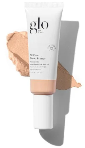 A tube of Glo Skin Beauty Oil Free Tinted Primer next to a swatch of the tinted product highlighting its smooth texture and natural finish.
